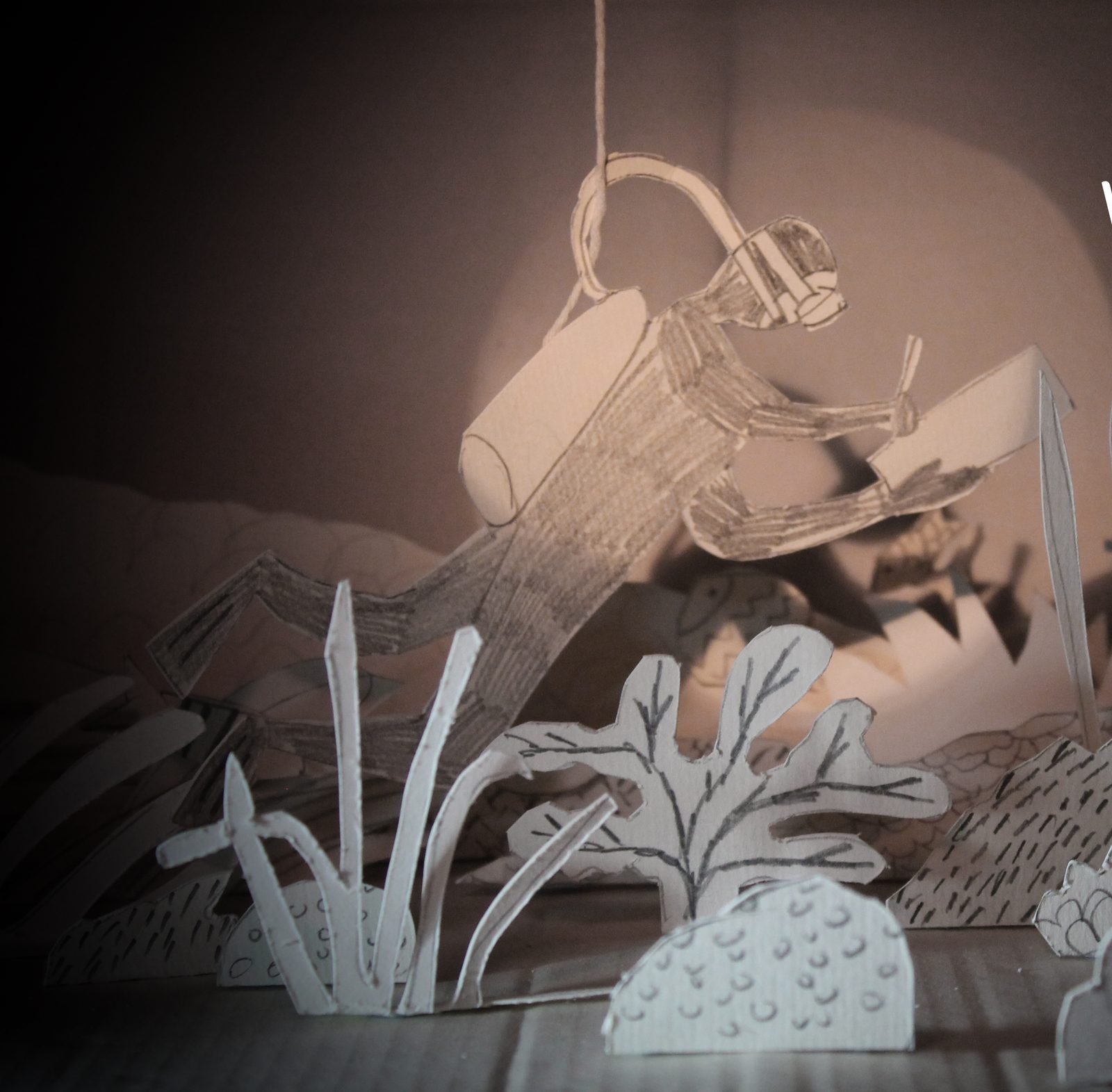 Paper diorama of a scuba diver surveying a reef